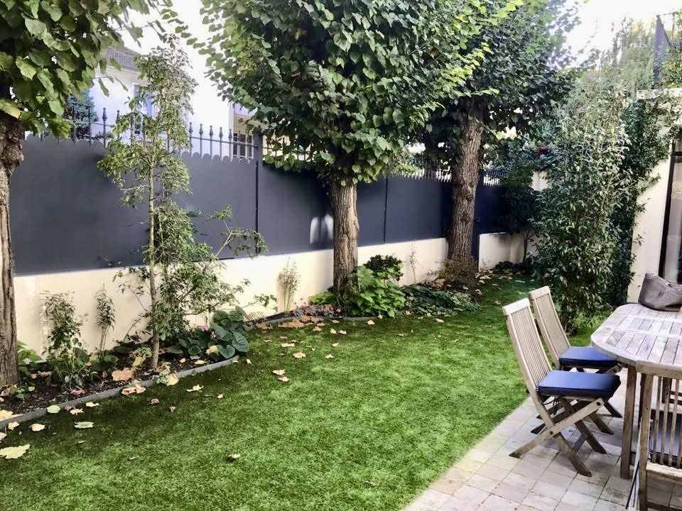 Clôture pleine en aluminium anthracite sur mur, côté jardin