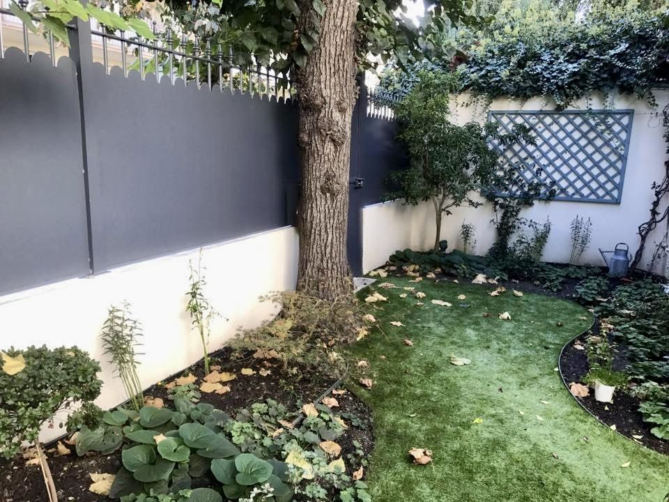 Panneaux pleins en aluminium anthracite posés sur un mur de jardin