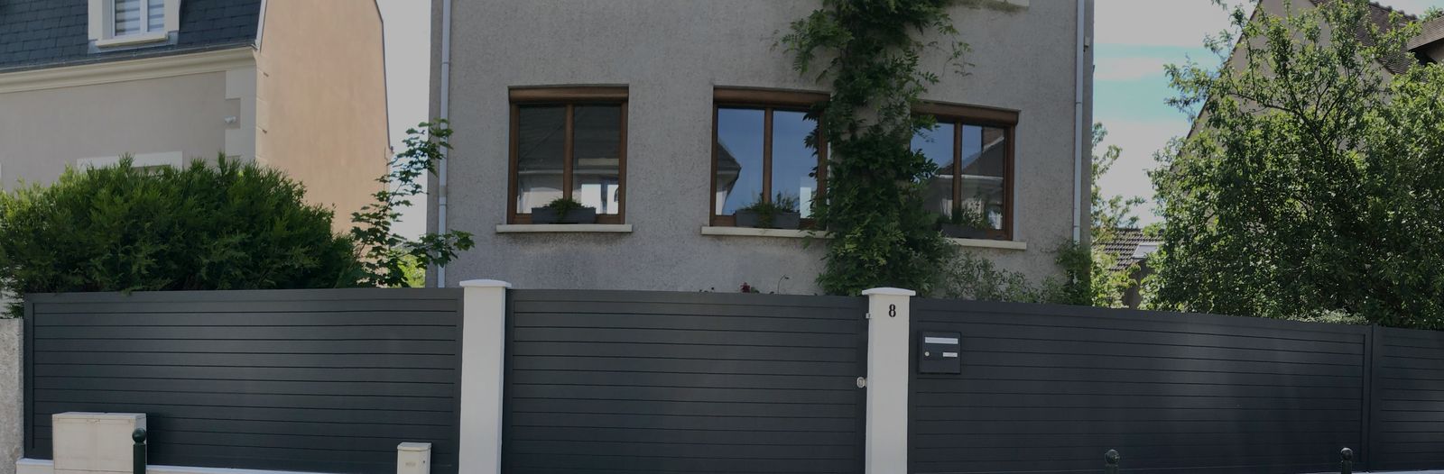 Portail coulissant et clôture en aluminium anthracite à lames horizontales sur muret blanc